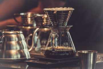 Pour-over-kaffe bryggs i glas med metallfilter och kanna